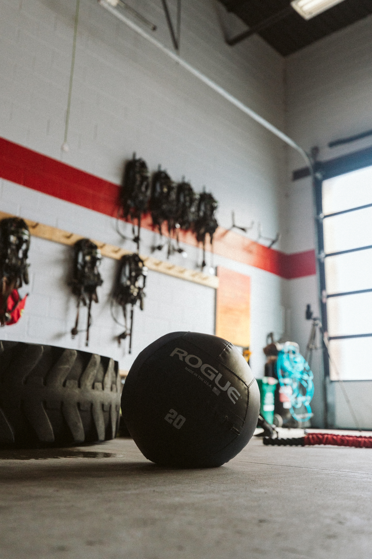 Rogue wall ball and tractor tire, with bunker gear hanging in the background.