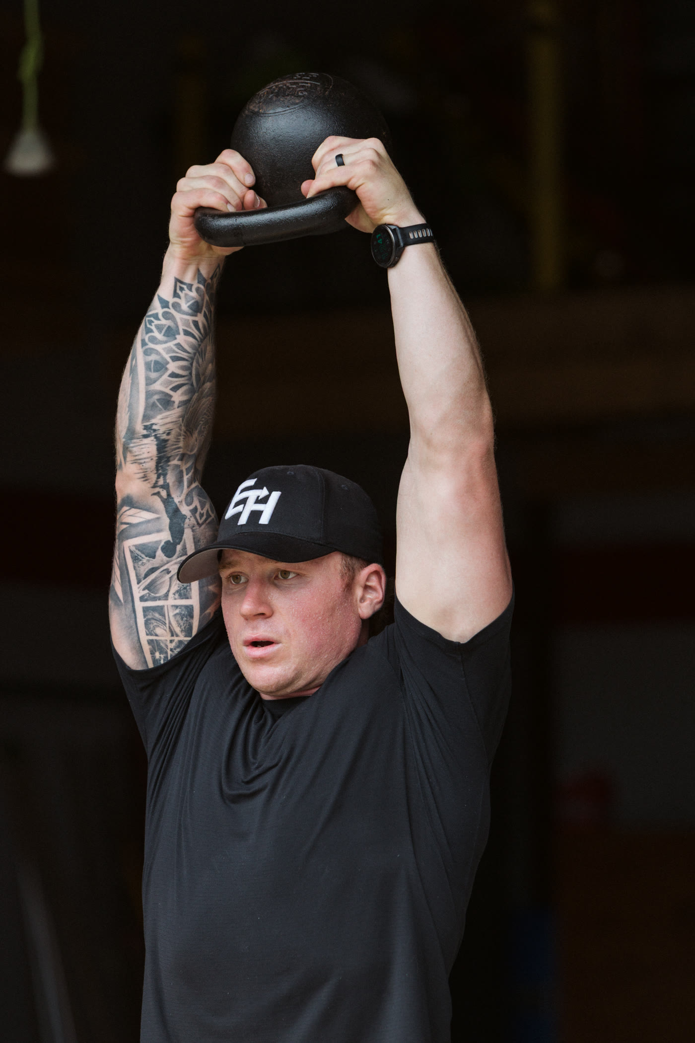 Coach Mitch pressing a kettlebell overhead.